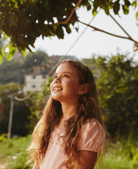 Niña mirando al cielo, vestido rosa