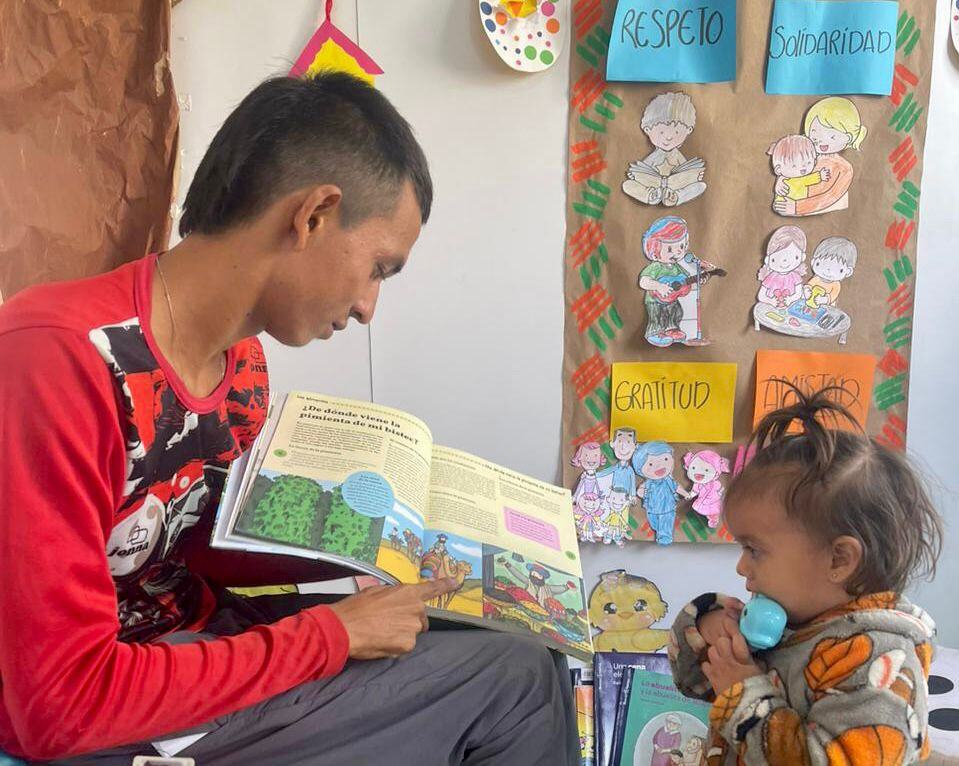 Padre y niña migrante en un Espacio Seguro para la Niñez